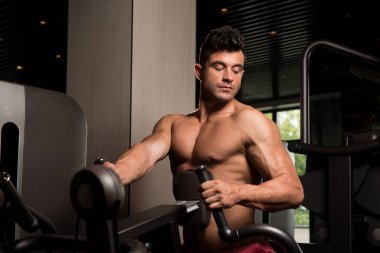 Kaslı adam arka için ağır egzersiz yaparak