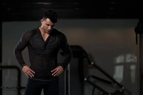 Siyah T-shirt arka plan spor salonunda güçlü adam — Stok fotoğraf