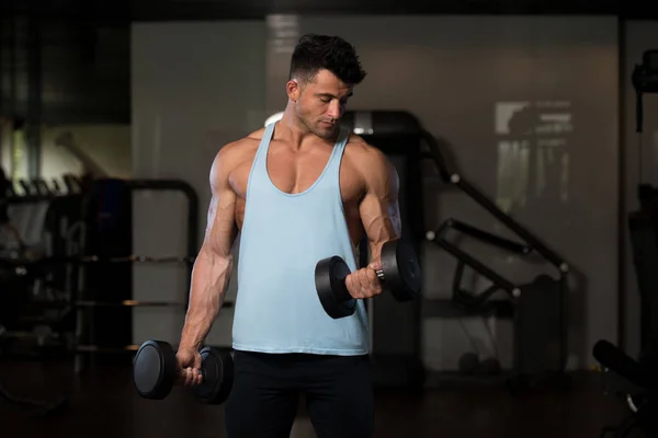 Ejercicio de bíceps con mancuerna en un gimnasio —  Fotos de Stock