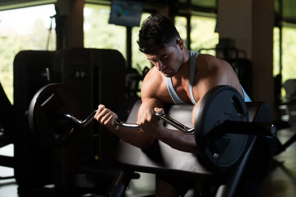 Biceps Exercise With Barbell in a Fitness Center — Stock Photo, Image