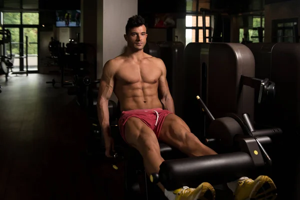 Hombre ejercitando las piernas en la máquina en el gimnasio Centar —  Fotos de Stock