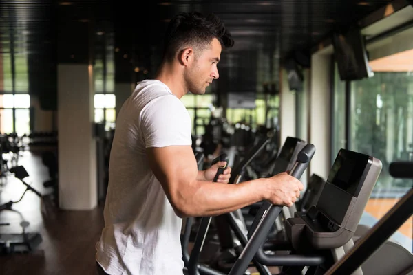 Uomo sano che fa aerobica ellittica Walker in palestra — Foto Stock