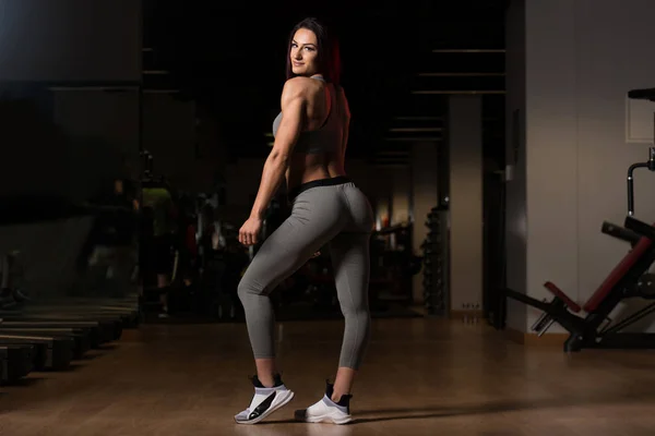 Mulher no ginásio mostrando seu corpo bem treinado — Fotografia de Stock