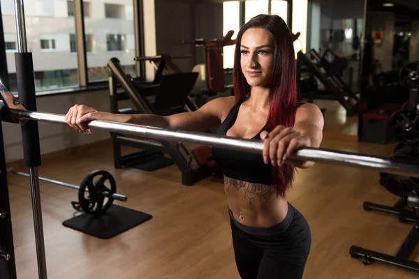 Mulher fitness se preparando para exercitar as pernas dentro do ginásio — Fotografia de Stock