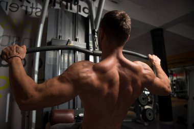 Kaslı adam arka için ağır egzersiz yaparak