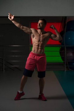 Yakışıklı kaslı adam içinde jimnastik salonu kas esneme