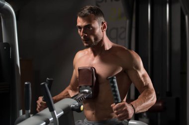 Kaslı adam arka için ağır egzersiz yaparak