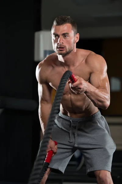 Mladý muž bojují lana v tělocvičně cvičení cvičení — Stock fotografie