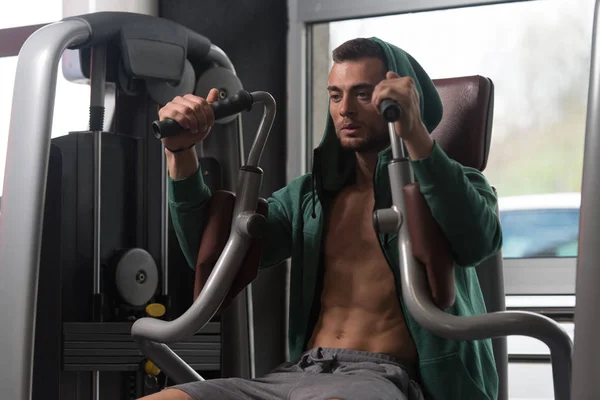 Homem exercitando peito na máquina — Fotografia de Stock