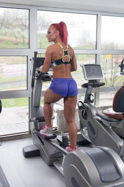 Sağlıklı kadın Fitness salonunda eliptik koşu bandı