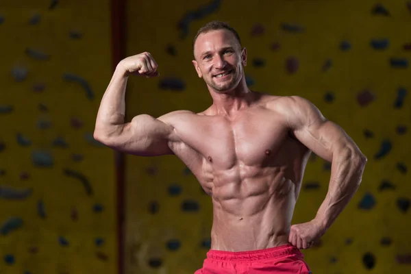 Muskulöser Bodybuilder zeigt seinen vorderen Bauch — Stockfoto