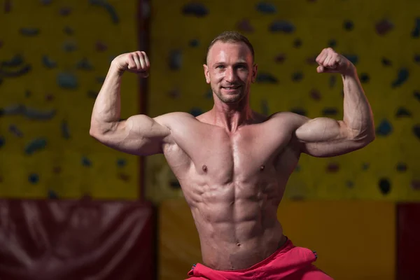 Svalnaté tělo tvůrce ukazující jeho přední dvojitý biceps — Stock fotografie