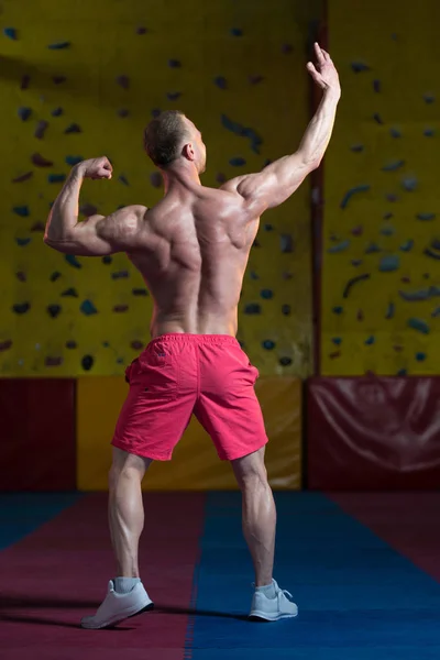 Gespierde bodybuilder tonen zijn terug dubbele biceps — Stockfoto