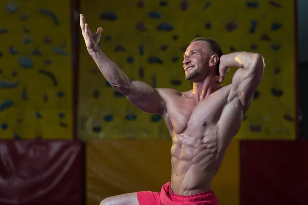 Uomo muscolare che flette i muscoli in palestra — Foto Stock