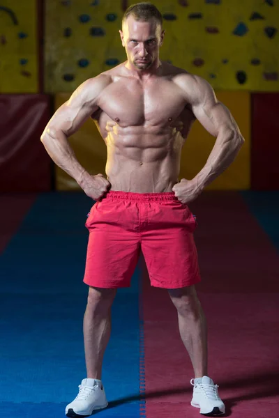 Hombre en el gimnasio mostrando su cuerpo bien entrenado — Foto de Stock