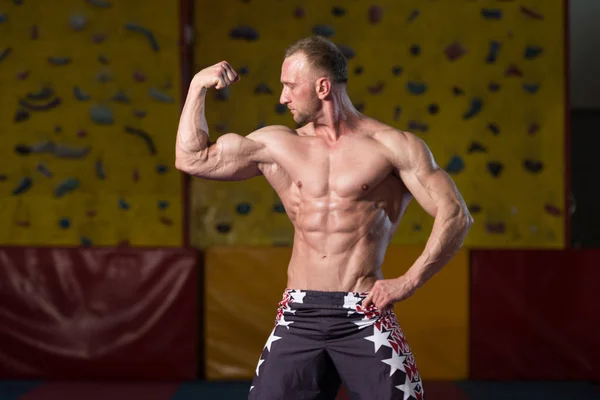 Σοβαρή bodybuilder που στέκεται στο γυμναστήριο — Φωτογραφία Αρχείου