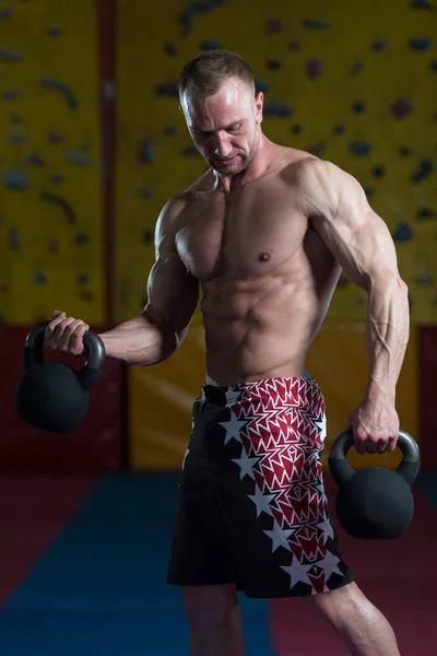 Fitness Man använda Kettlebells insidan Gym — Stockfoto