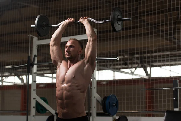 Człowiek na siłowni, ćwiczenia na triceps z brzana — Zdjęcie stockowe