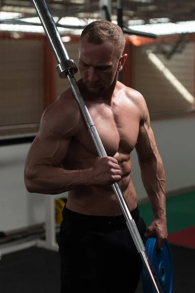 展示肌肉与杠铃和权重的男人 — 图库照片