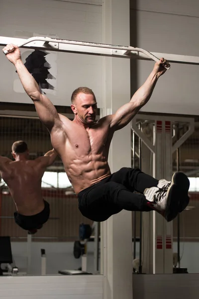 Abs egzersiz bacak asılı gerçekleştirme adam yükseltir — Stok fotoğraf