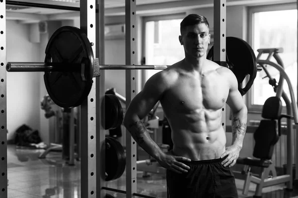 Hombre muscular descansando en el gimnasio después del ejercicio —  Fotos de Stock