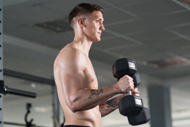 Pazı egzersiz Dumbbells ile genç adam