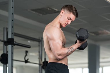 Pazı egzersiz Dumbbells ile genç adam