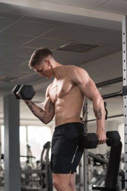 Pazı egzersiz bir spor salonunda Dumbbells ile