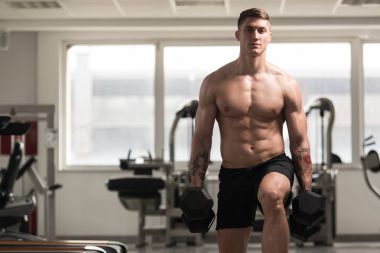 Dumbbells ile bacaklar için egzersiz yaparak atlet