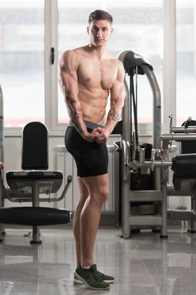 Hombre en el gimnasio mostrando su cuerpo bien entrenado — Foto de Stock