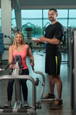 Kadın trende makine kişisel antrenör ile geri