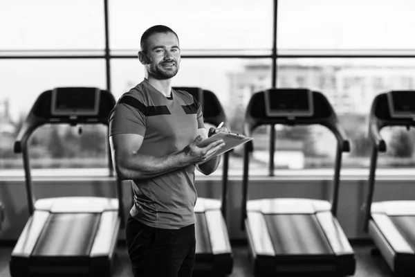 Personal Trainer toma notas na área de transferência no ginásio — Fotografia de Stock