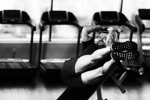Trener robi ćwiczenia brzucha na regulowane ławki — Zdjęcie stockowe