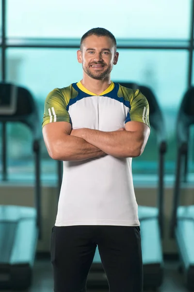 Bonito personal trainer vestindo roupas esportivas no centro de fitness — Fotografia de Stock