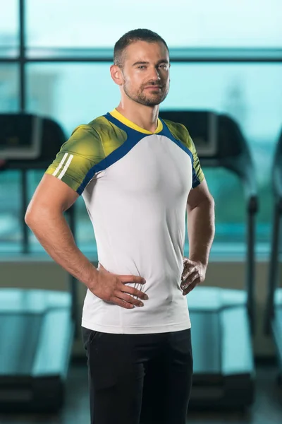 Bonito personal trainer vestindo roupas esportivas no centro de fitness — Fotografia de Stock