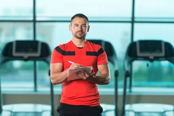 Personal Trainer prende appunti sugli appunti in palestra — Foto Stock