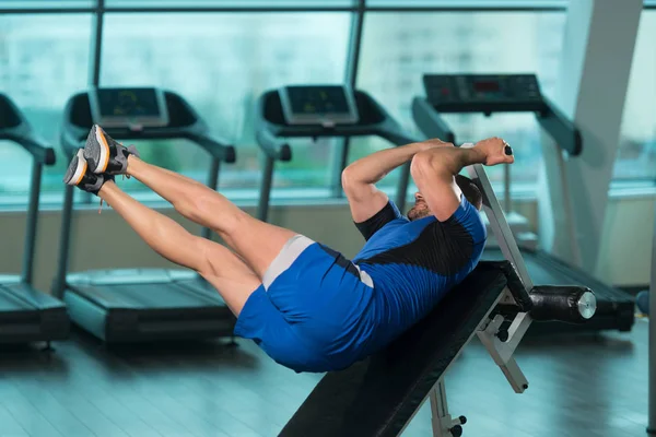 Entrenador haciendo ejercicio para el abdomen en banco ajustable — Foto de Stock