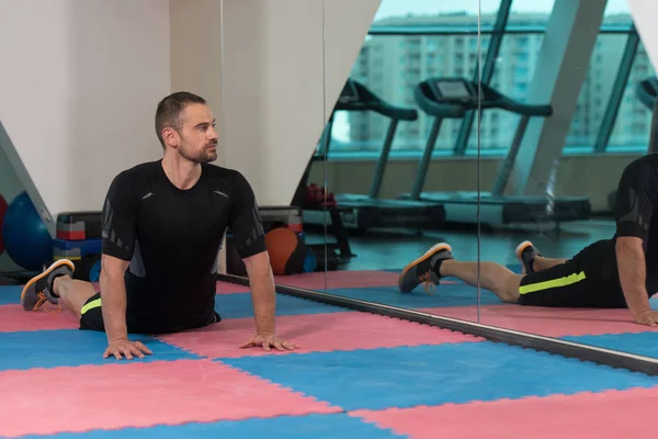 Atletische man strekt zich uit — Stockfoto