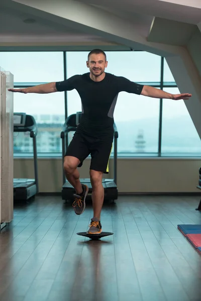 Treinador pessoal fazendo exercício na bola de equilíbrio Bosu — Fotografia de Stock