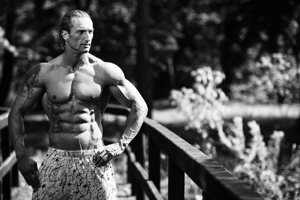 Bodybuilder Flexing Muscles Outdoors In Nature — Stock Photo, Image