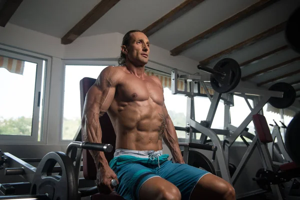 Homme exerçant trapèze dans la salle de gym — Photo