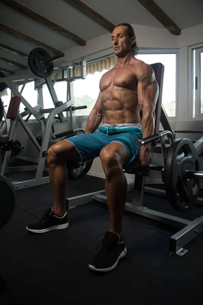 Muscular hombre ejercicio trapecio en la máquina —  Fotos de Stock