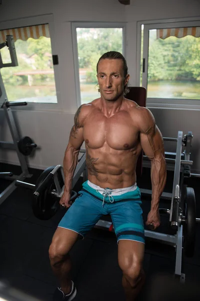 Muskulöser Mann übt Trapez an Maschine — Stockfoto