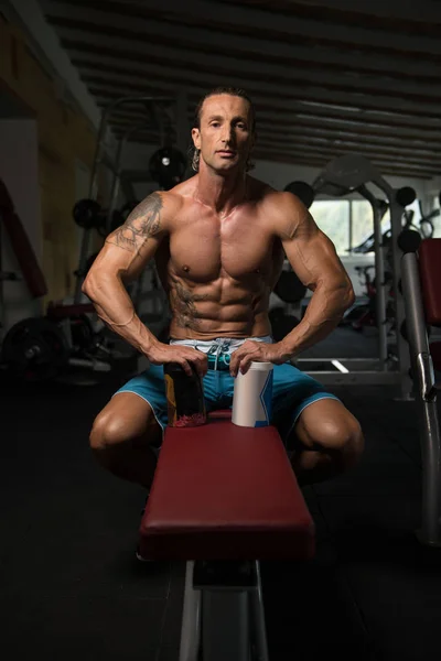 Bodybuilder posant avec des suppléments pour l'espace de copie — Photo