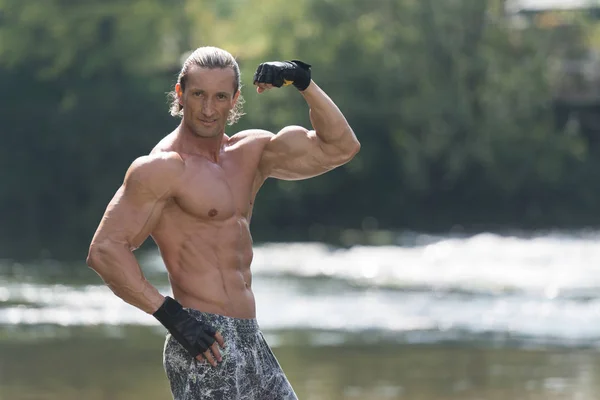 Handsome Mucular Man Flexing Muscles Outdoors In Nature — Stock Photo, Image