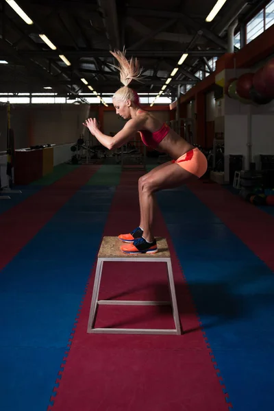 Mujer haciendo ejercicio con caja de ajuste en el gimnasio —  Fotos de Stock