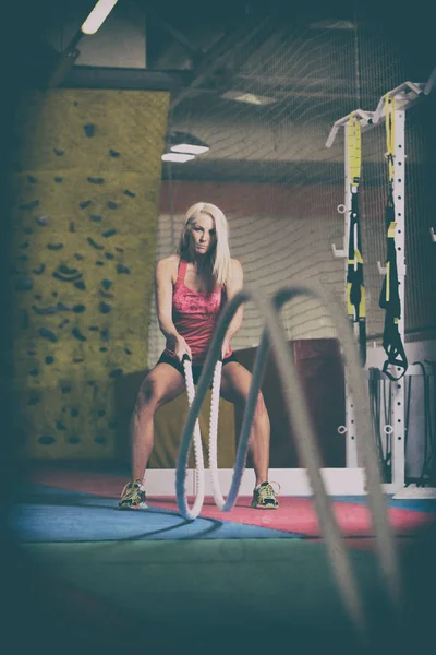 Jovem mulher batalhando cordas no exercício de ginástica — Fotografia de Stock