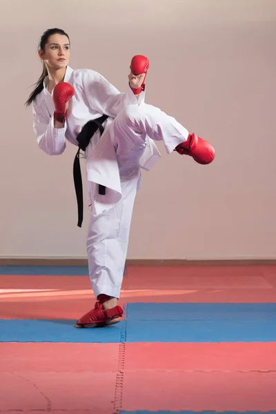Женщина в белом кимоно и черный пояс тренировки карате — стоковое фото