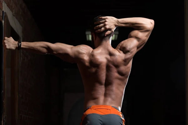 Muskulös modell flexar tillbaka muskler Pose — Stockfoto