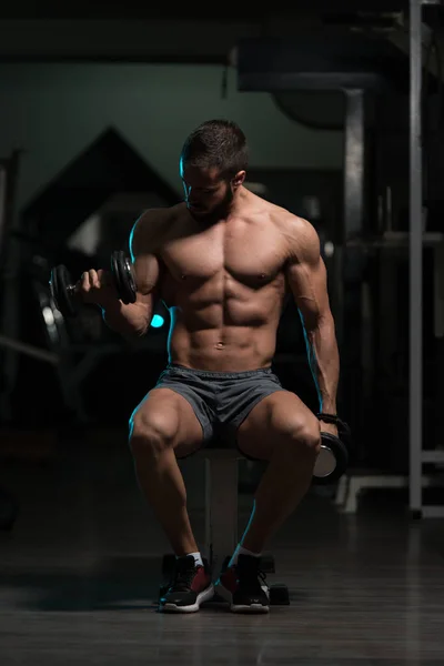 Biceps exercice avec haltères dans une salle de gym — Photo